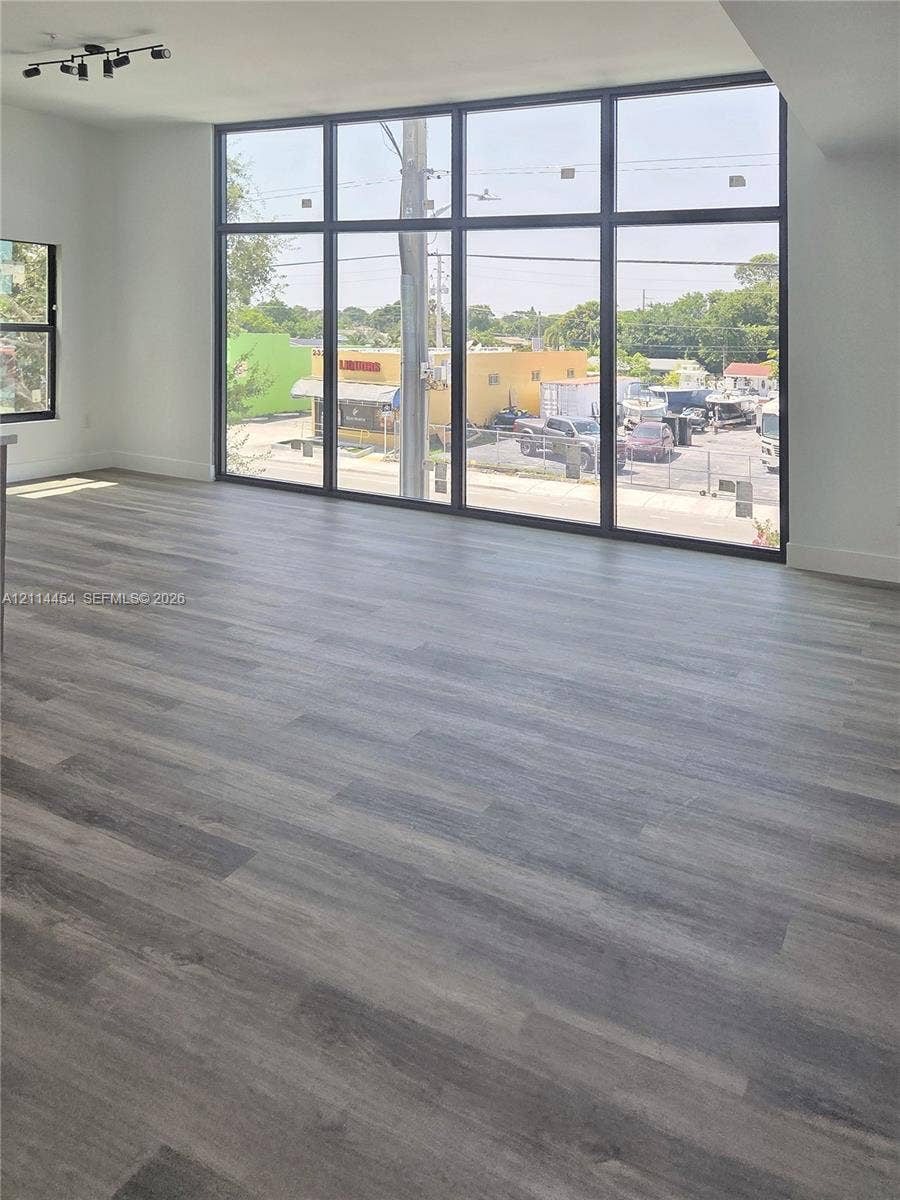 401 Pembroke Road, #203, Hallandale Beach, Hallandale Beach, FL 33009 Floor-to-ceiling windows with black frames, wood-finish flooring, and black multi-directional track lighting