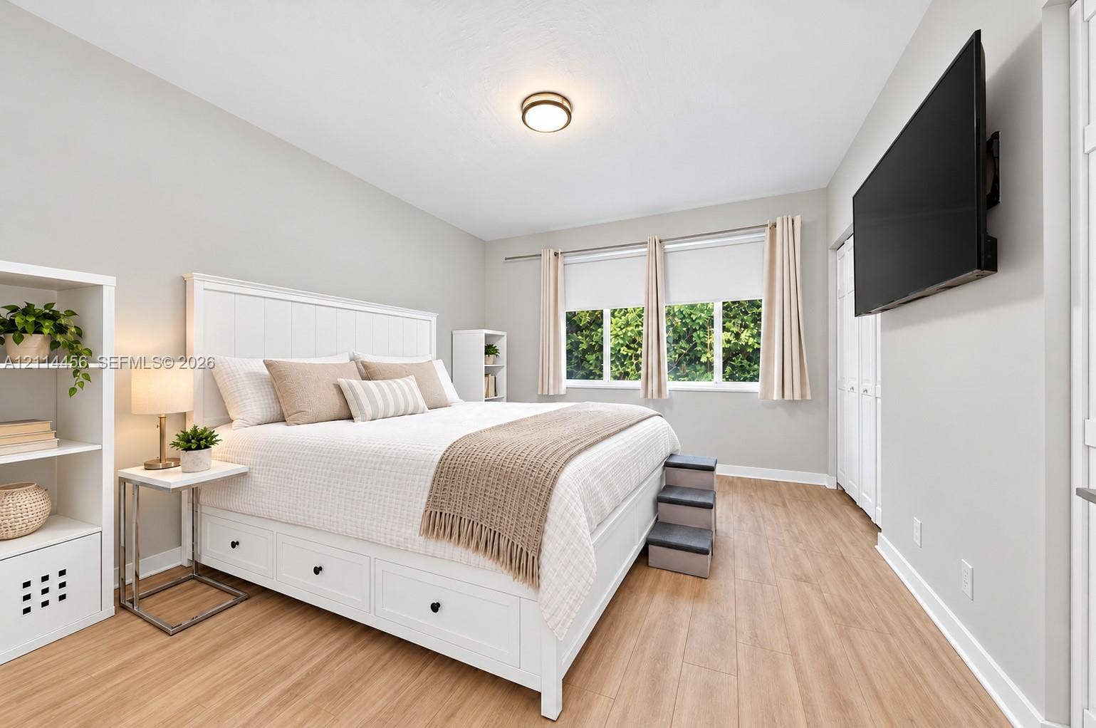 Neutral-toned interior featuring wood-finish flooring, a flush-mount light fixture, and windows with horizontal panes
