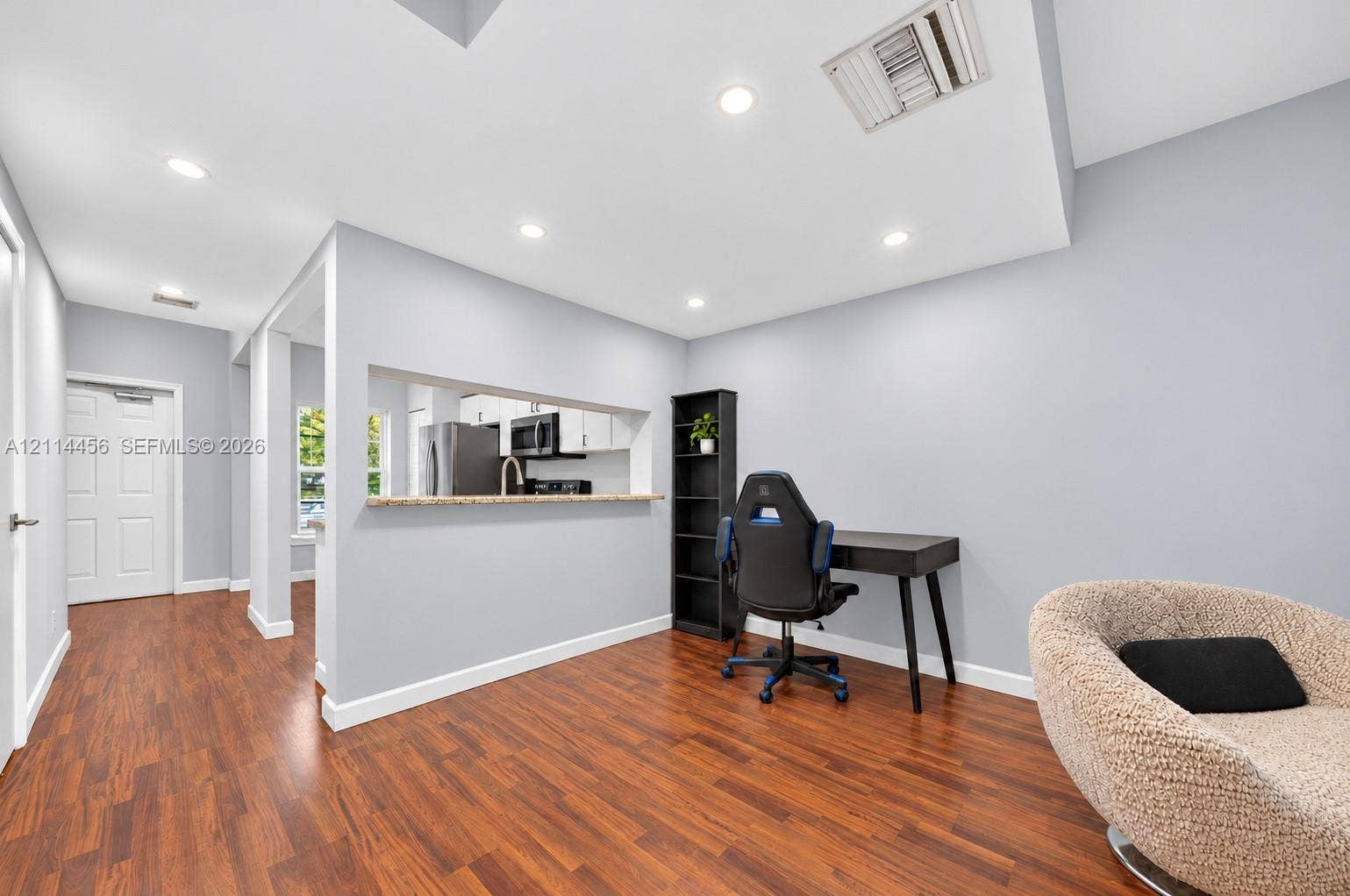 Interior space featuring wood-finish flooring, recessed lighting, and a pass-through window with a stone-surfaced ledge