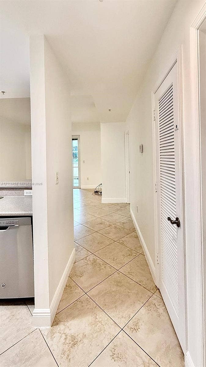 1203 Town Center Drive, #207, Jupiter, Jupiter, FL 33458 Diagonal tile flooring, stainless steel dishwasher, and louvered closet door with a metallic knob