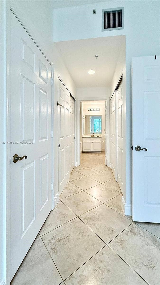 1203 Town Center Drive, #207, Jupiter, Jupiter, FL 33458 Hallway featuring diagonal-set tile flooring, multiple six-panel interior doors, and recessed lighting