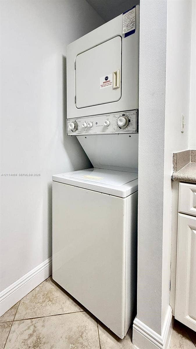1203 Town Center Drive, #207, Jupiter, Jupiter, FL 33458 Stacked laundry unit featuring a top-load washer, a front-load dryer, and natural stone-finish floor tiling