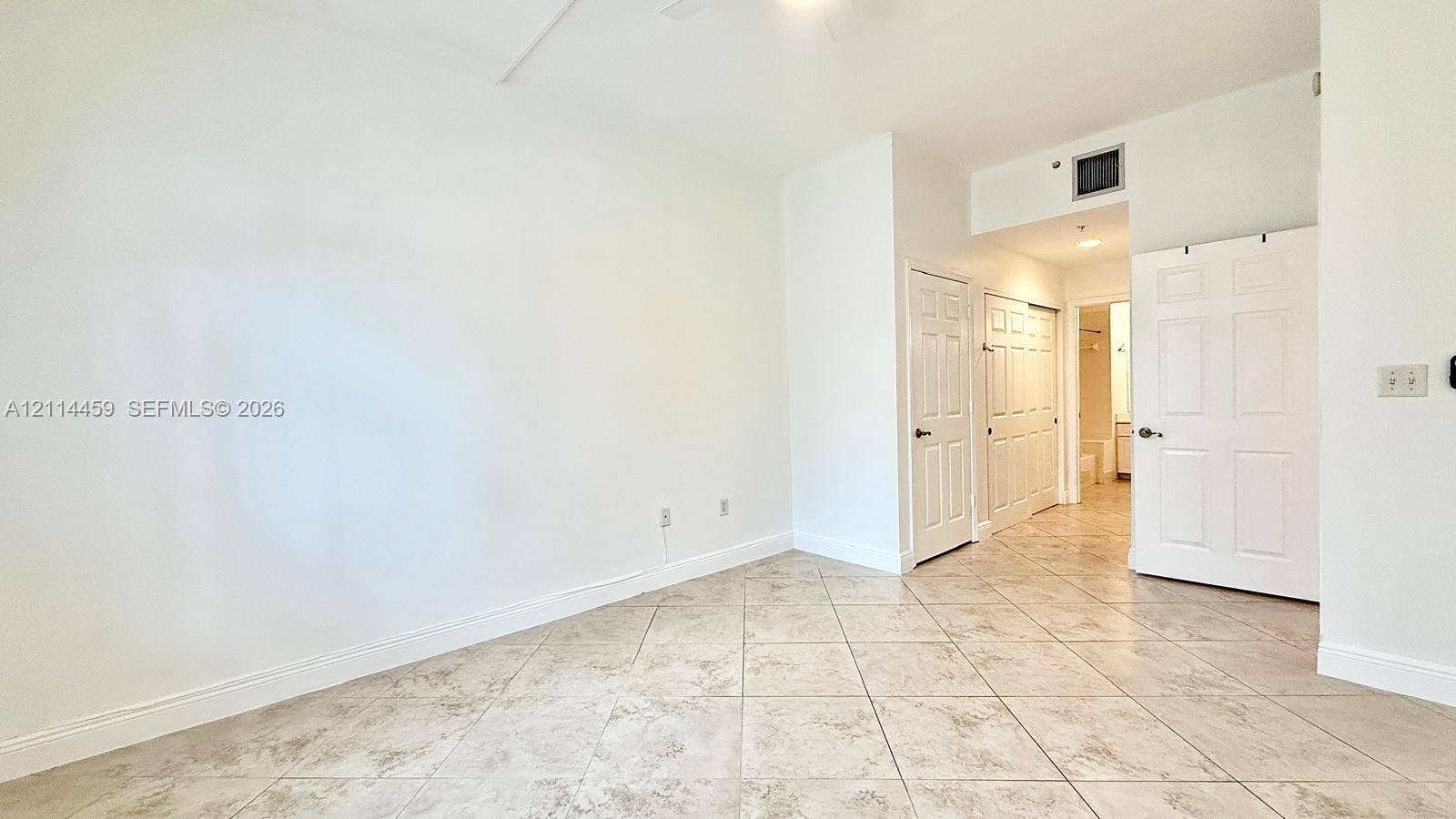 1203 Town Center Drive, #207, Jupiter, Jupiter, FL 33458 Neutral-toned ceramic tile flooring, three white six-panel interior doors, and a ceiling-mounted light fixture