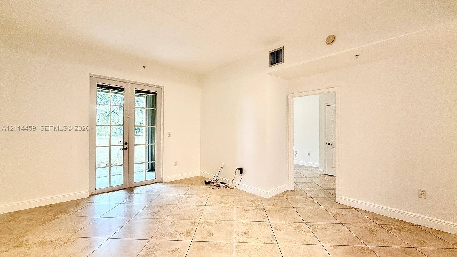 1203 Town Center Drive, #207, Jupiter, Jupiter, FL 33458 Neutral interior space featuring ceramic tile flooring, white walls, and glass-paneled double doors
