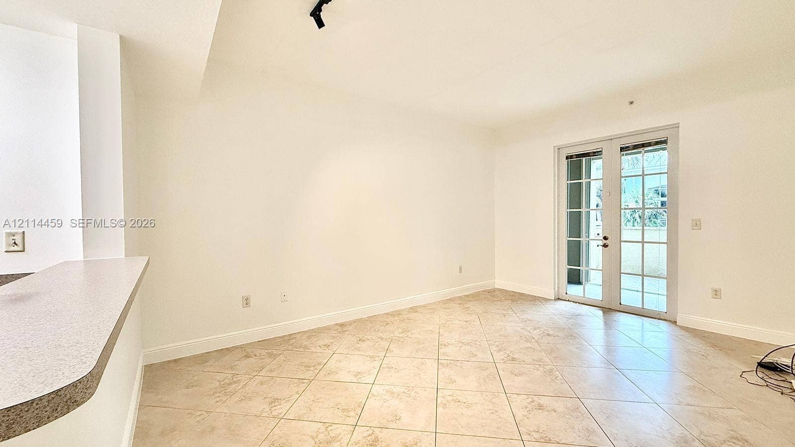 1203 Town Center Drive, #207, Jupiter, Jupiter, FL 33458 Neutral-toned ceramic tile flooring, French doors with glass panes, and a built-in kitchen breakfast bar
