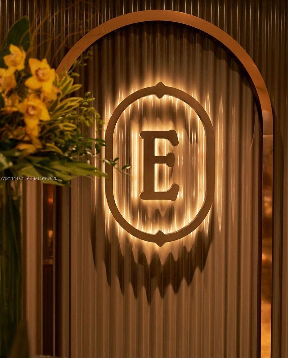 398 NE 5th Street, #4001, Miami, FL 33132 Arched entryway featuring ribbed wall paneling and a custom backlit metal insignia