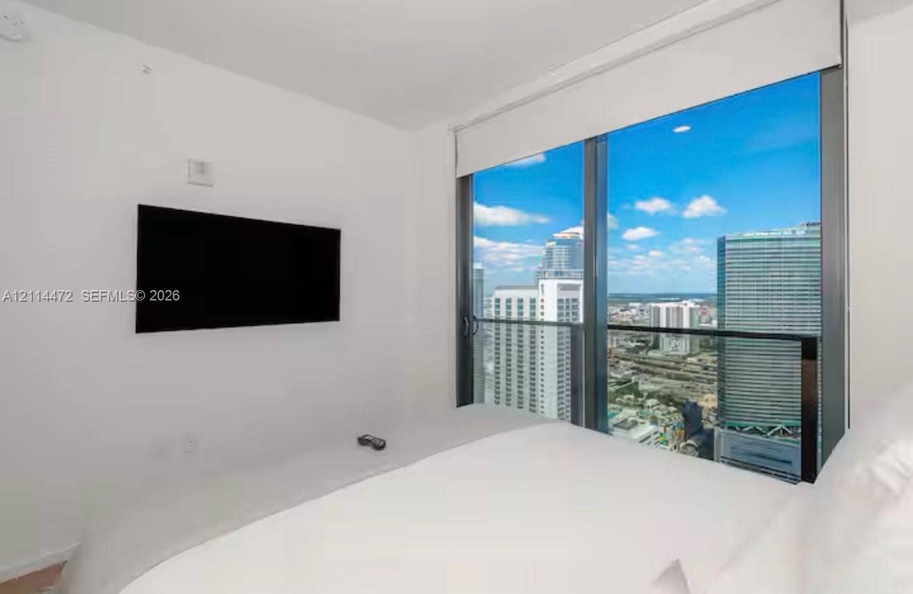 398 NE 5th Street, #4001, Miami, FL 33132 Floor-to-ceiling windows, attached glass-railed balcony, and urban cityscape backdrop