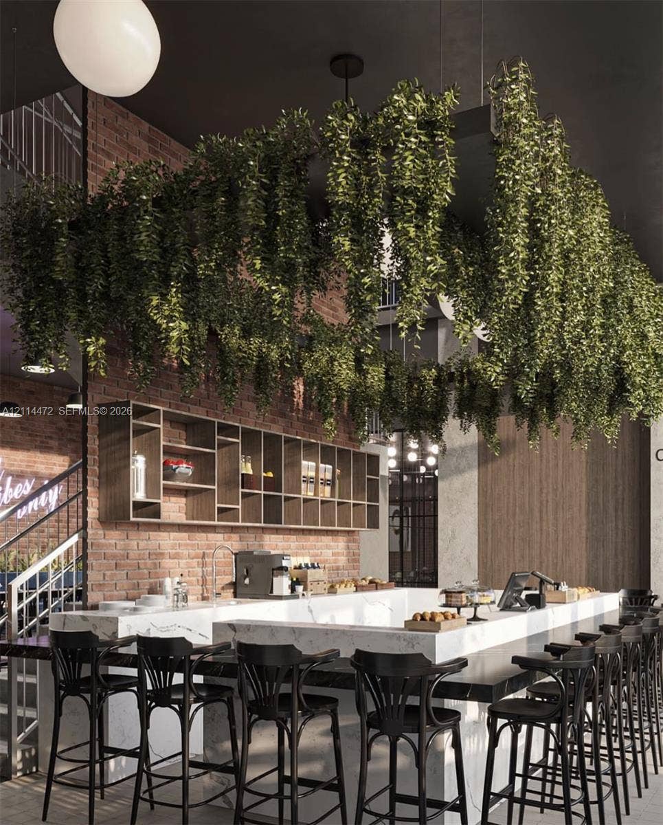 398 NE 5th Street, #4001, Miami, FL 33132 Exposed brick walls, custom built-in wood shelving, and a stone-topped bar counter featuring a prominent overhead suspended planter