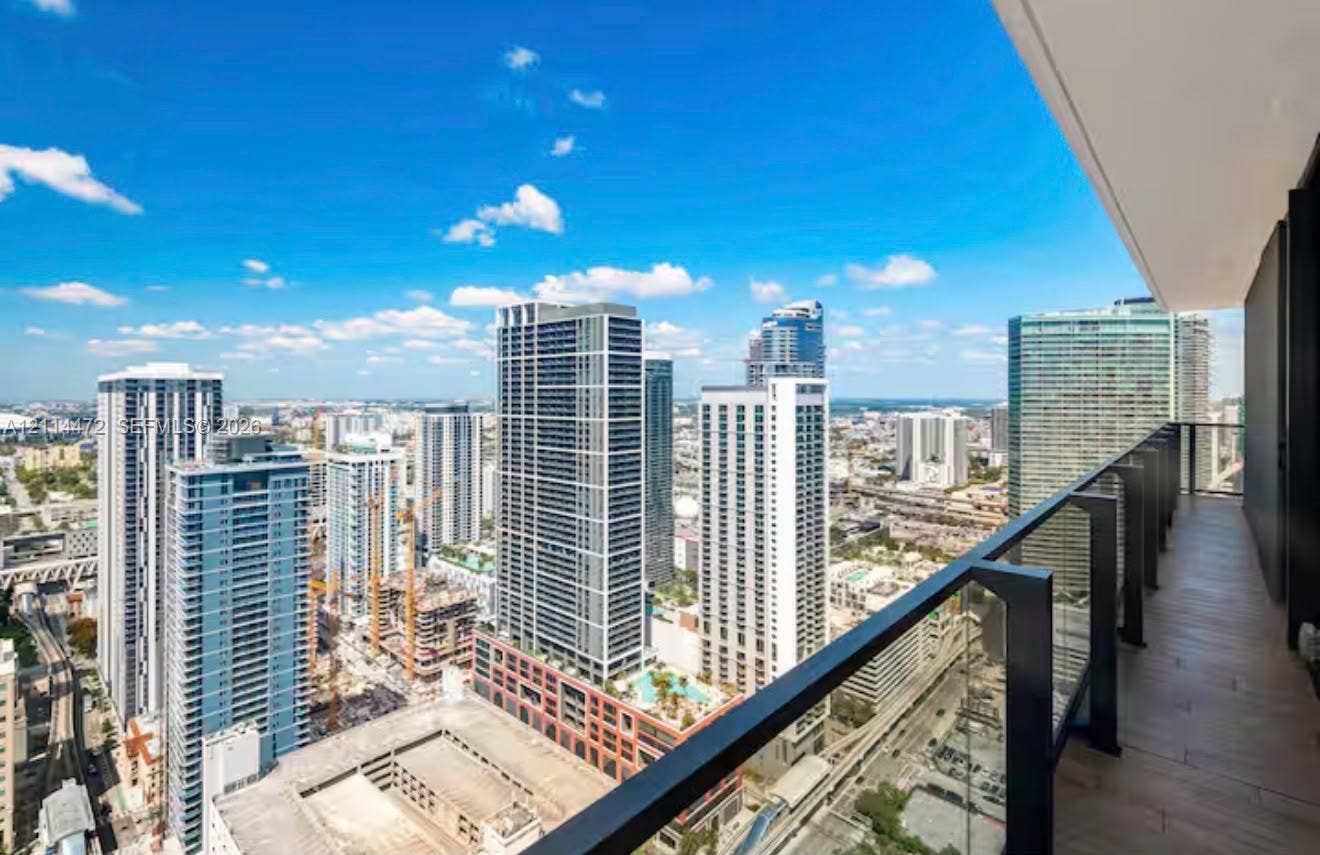 398 NE 5th Street, #4001, Miami, FL 33132 Covered balcony featuring wood-finish flooring and a glass railing with a metal frame