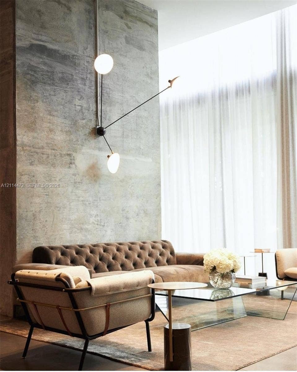 398 NE 5th Street, #4001, Miami, FL 33132 Exposed concrete accent wall with floor-to-ceiling height, multi-arm wall-mounted light fixture with globe bulbs, and full-height window drapery