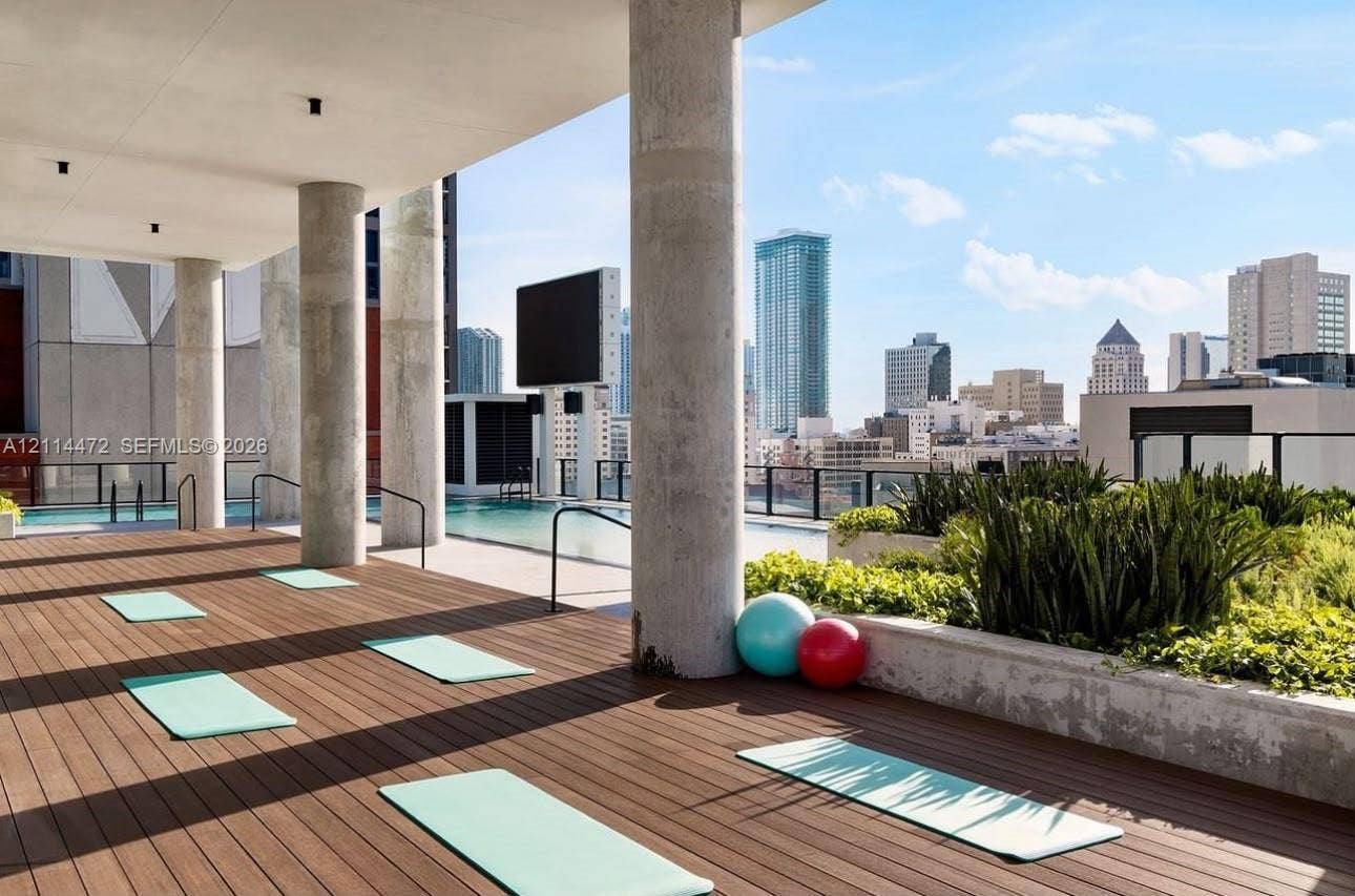 398 NE 5th Street, #4001, Miami, FL 33132 Rooftop terrace featuring wood-finish decking, concrete columns, a swimming pool, and built-in concrete planters
