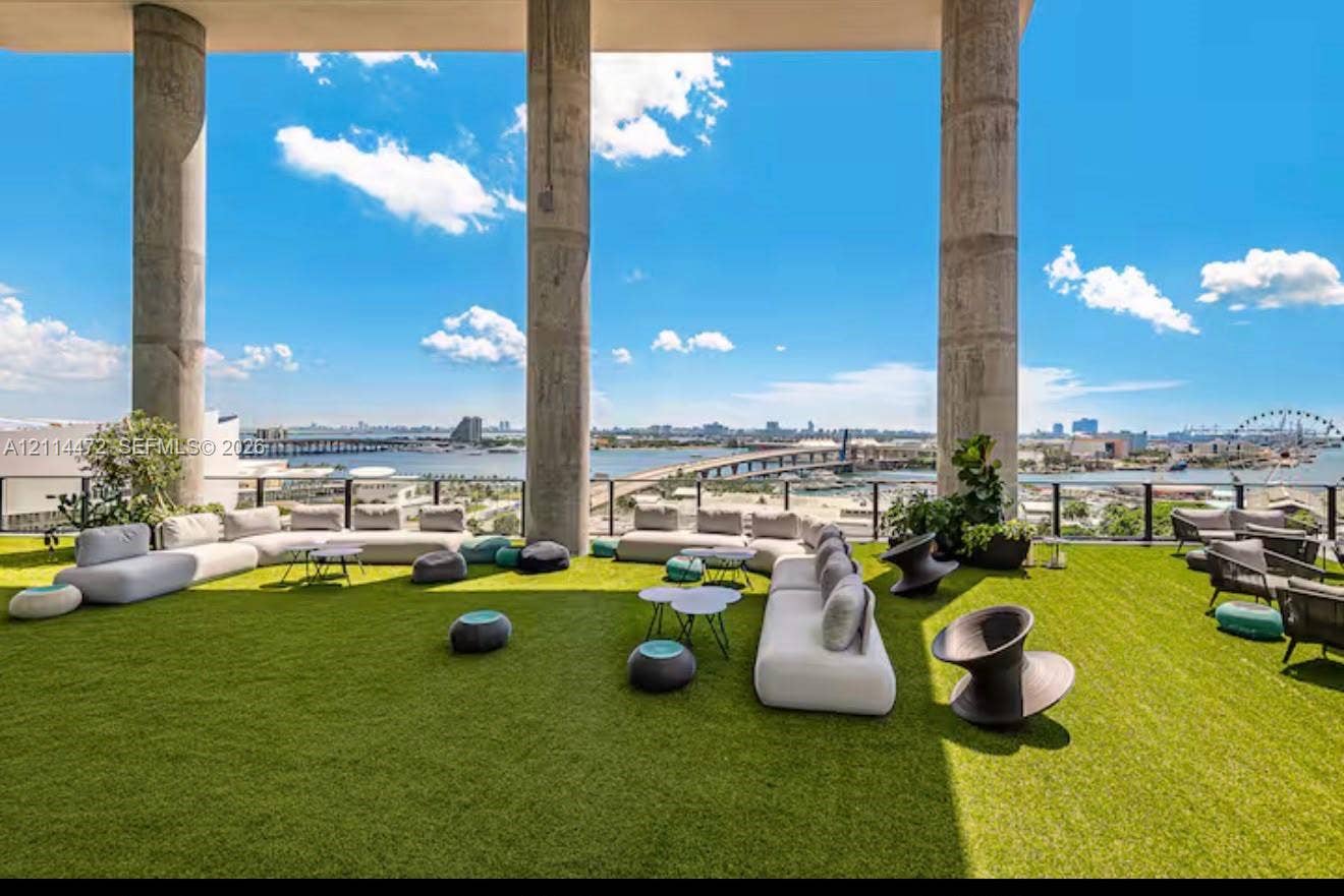 398 NE 5th Street, #4001, Miami, FL 33132 Expansive outdoor terrace featuring synthetic turf flooring, floor-to-ceiling structural concrete columns, and a perimeter metal railing