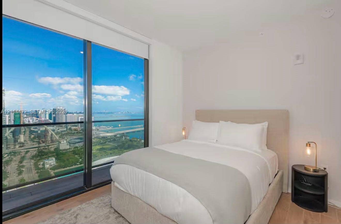 398 NE 5th Street, #4001, Miami, FL 33132 Floor-to-ceiling windows, wood-finish flooring, and expansive urban and water scenery