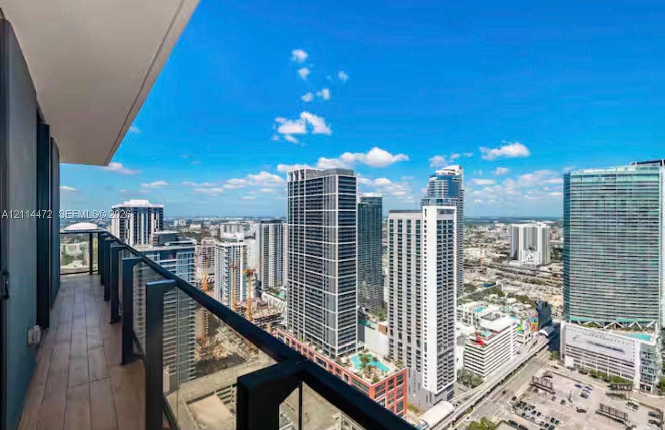 398 NE 5th Street, #4001, Miami, FL 33132 Private balcony featuring wood-finish flooring and a tempered glass railing with a metal frame
