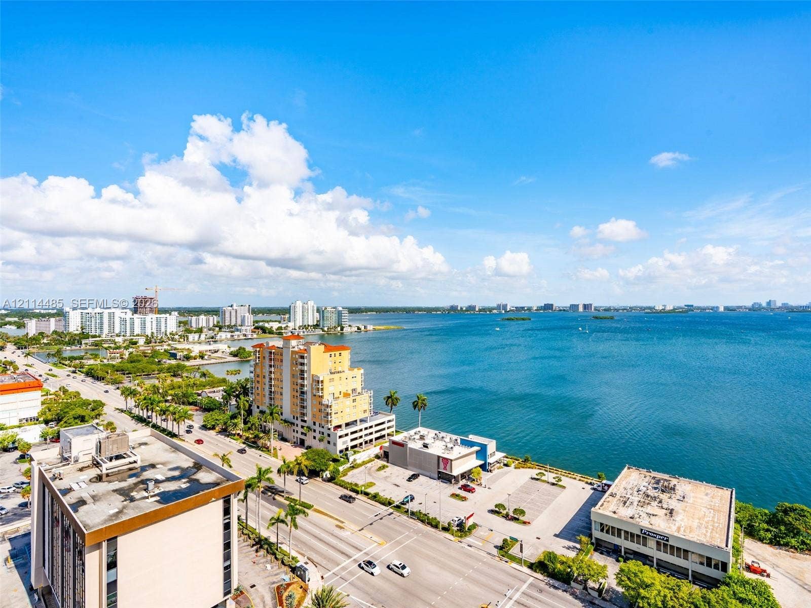 Aerial perspective of an urban waterfront location featuring coastal proximity, multi-story building structures, and surrounding thoroughfares