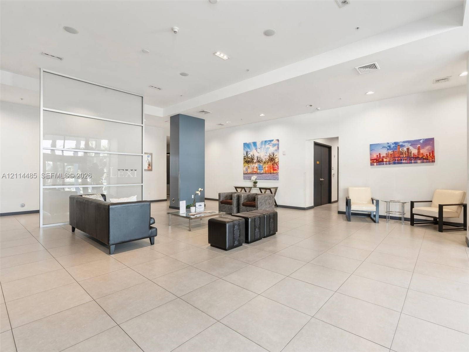 Open-concept lobby featuring large-format tile flooring, recessed ceiling lighting, and a frosted glass partition