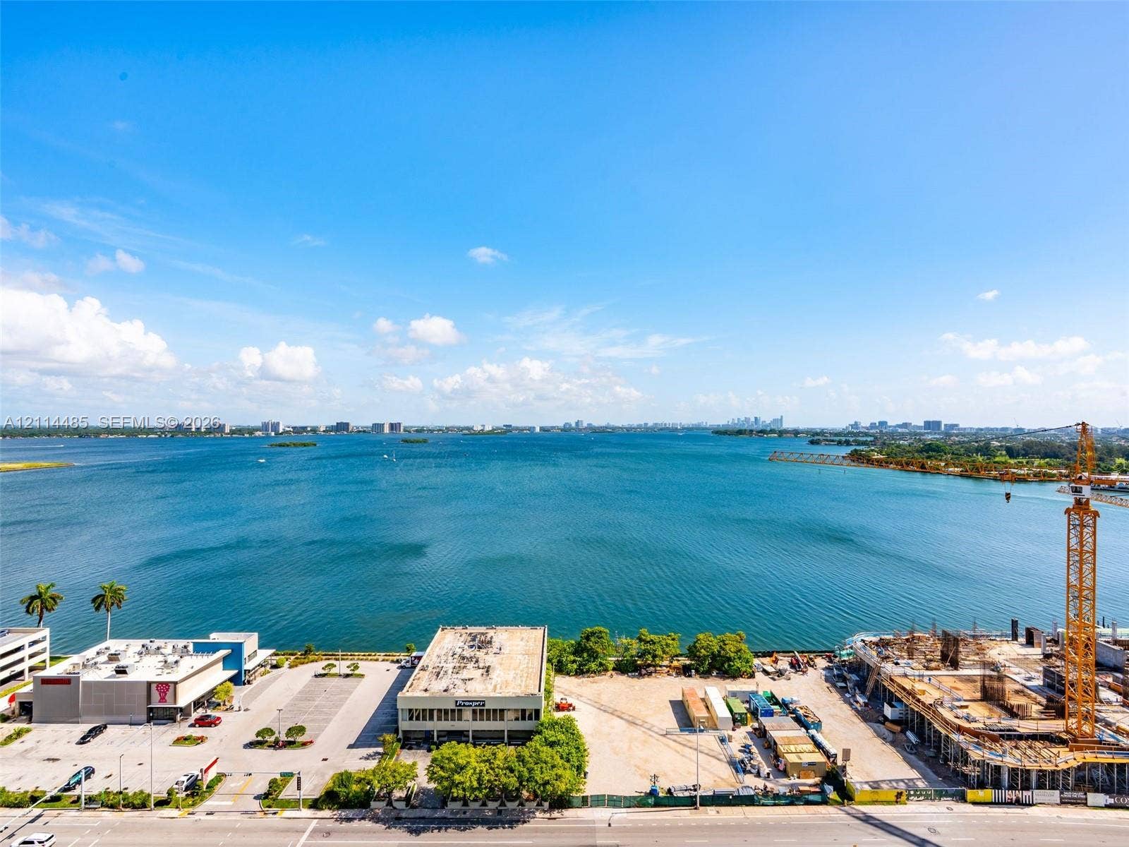Expansive water frontage featuring a clear line of sight across a large bay to a distant cityscape skyline