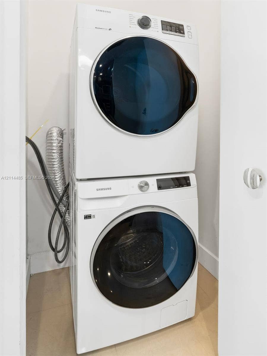 Stacked white front-load washer and dryer unit with glass-front doors