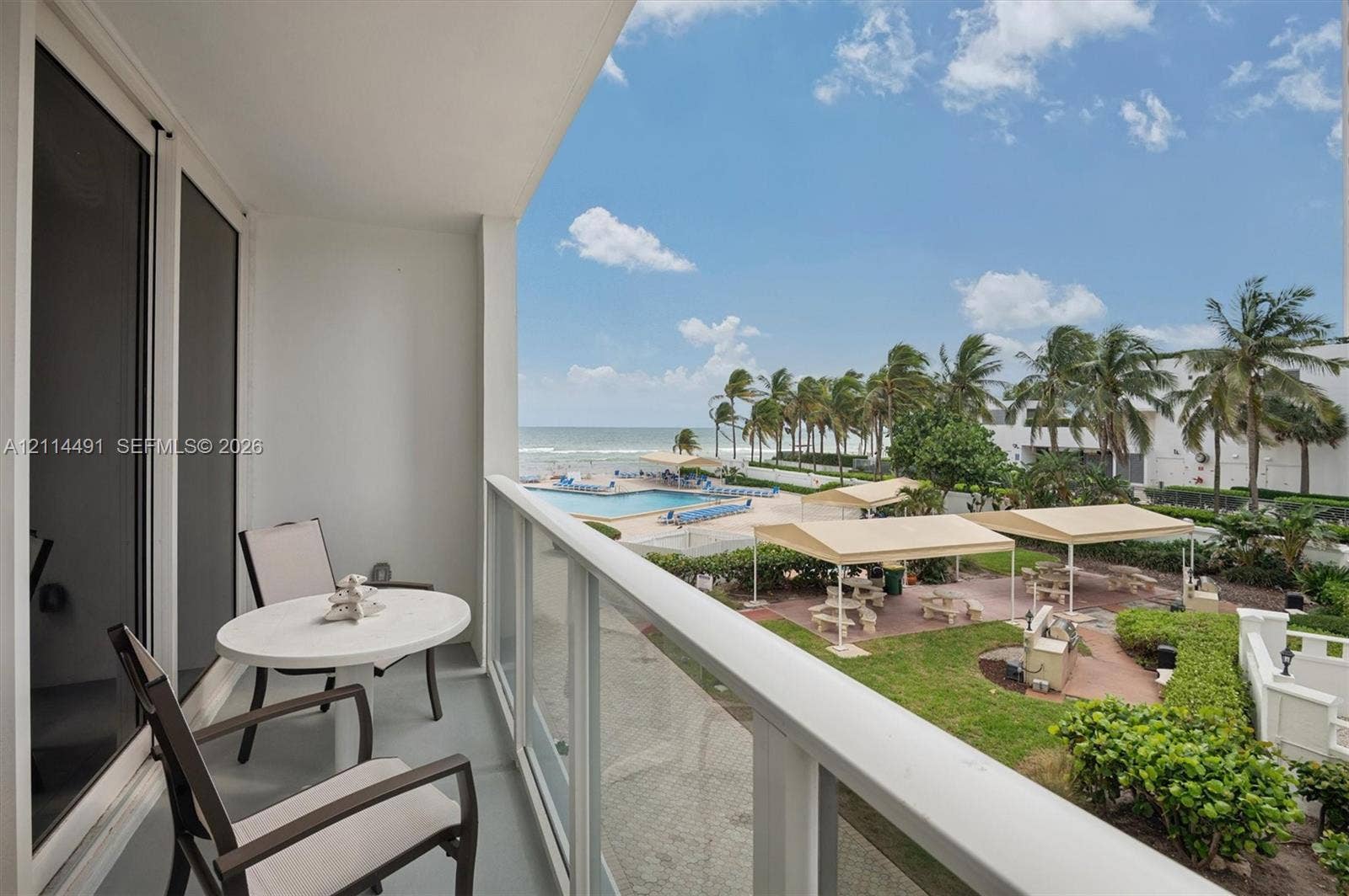 3505 S Ocean Drive, #217, Hollywood, FL 33019 Covered balcony featuring a glass-panel railing, concrete flooring, and a sliding glass door entry