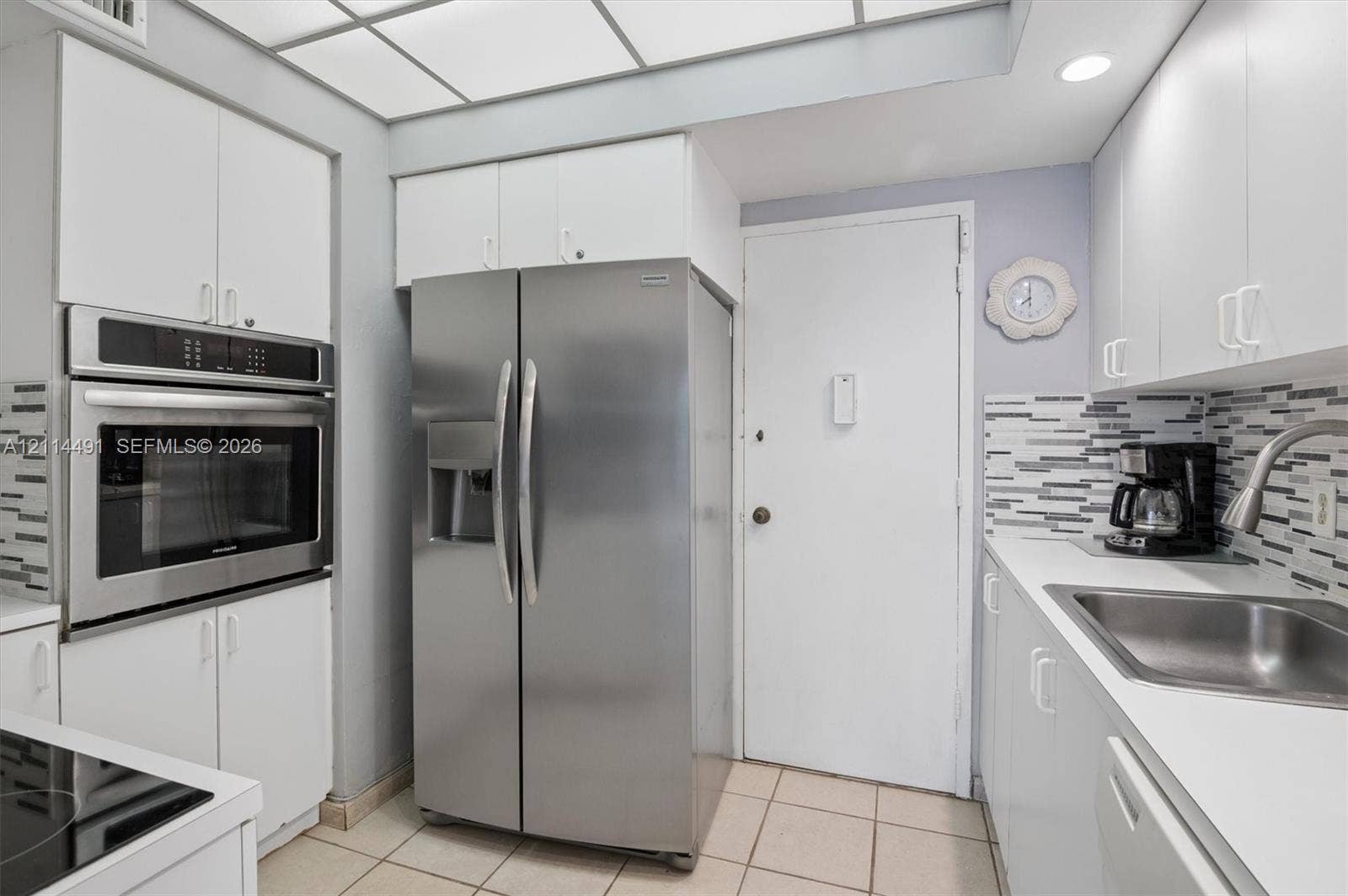 3505 S Ocean Drive, #217, Hollywood, FL 33019 Kitchen featuring white cabinetry, stainless steel side-by-side refrigerator, built-in stainless steel wall oven, tile backsplash, and recessed lighting