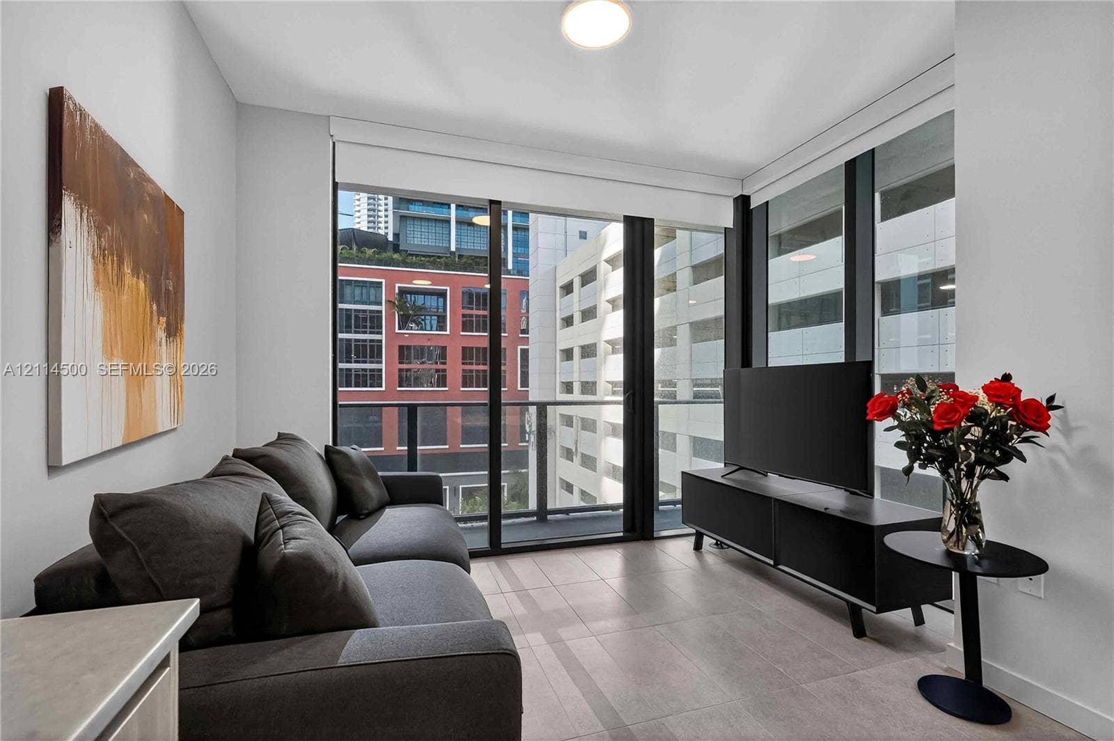 121 NE 5th Street, #712B, Miami, FL 33132 Floor-to-ceiling windows, private balcony, neutral large-format tile flooring, and crisp white wall finishes