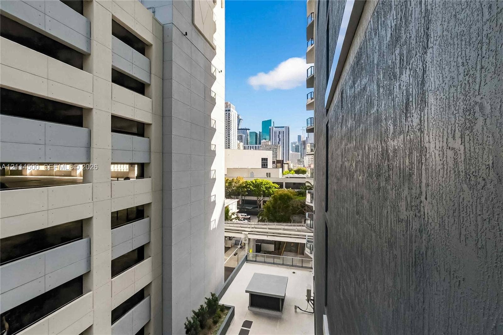 121 NE 5th Street, #712B, Miami, FL 33132 Urban skyline landscape featuring textured charcoal-colored exterior siding, light-toned concrete structural facade, and tiered high-rise architecture