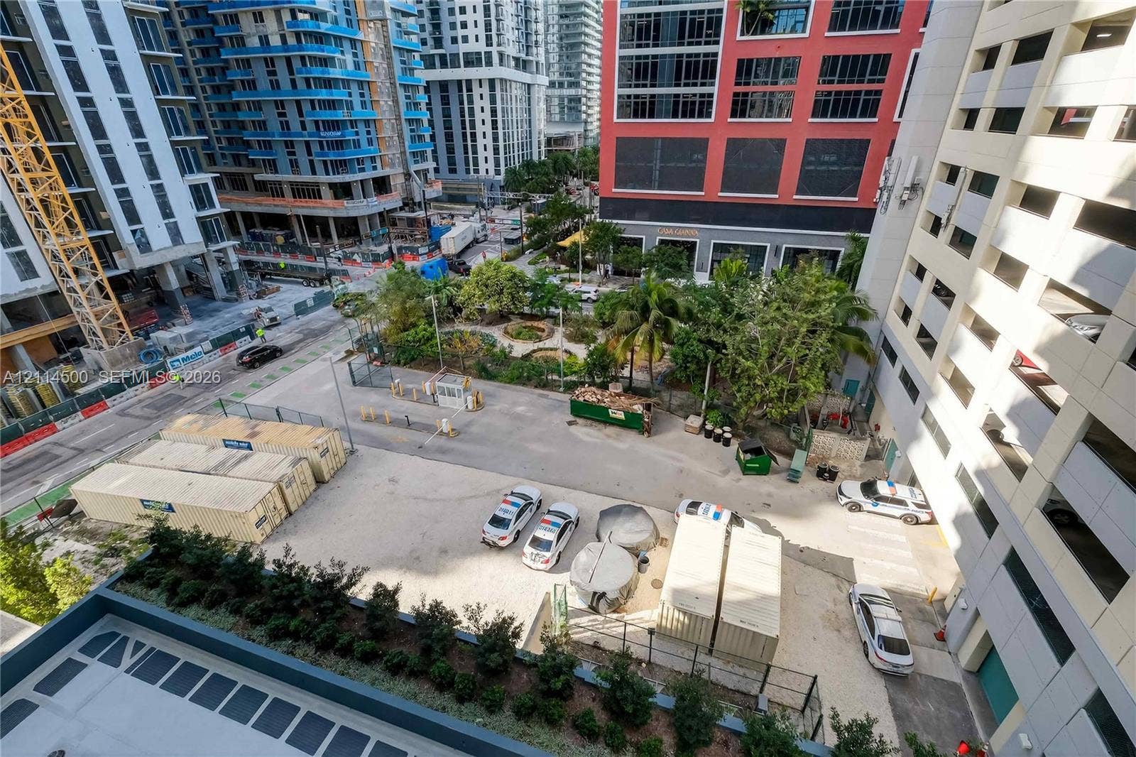 121 NE 5th Street, #712B, Miami, FL 33132 Urban outdoor space featuring mature palm trees, landscaped garden beds, and paved ground cover