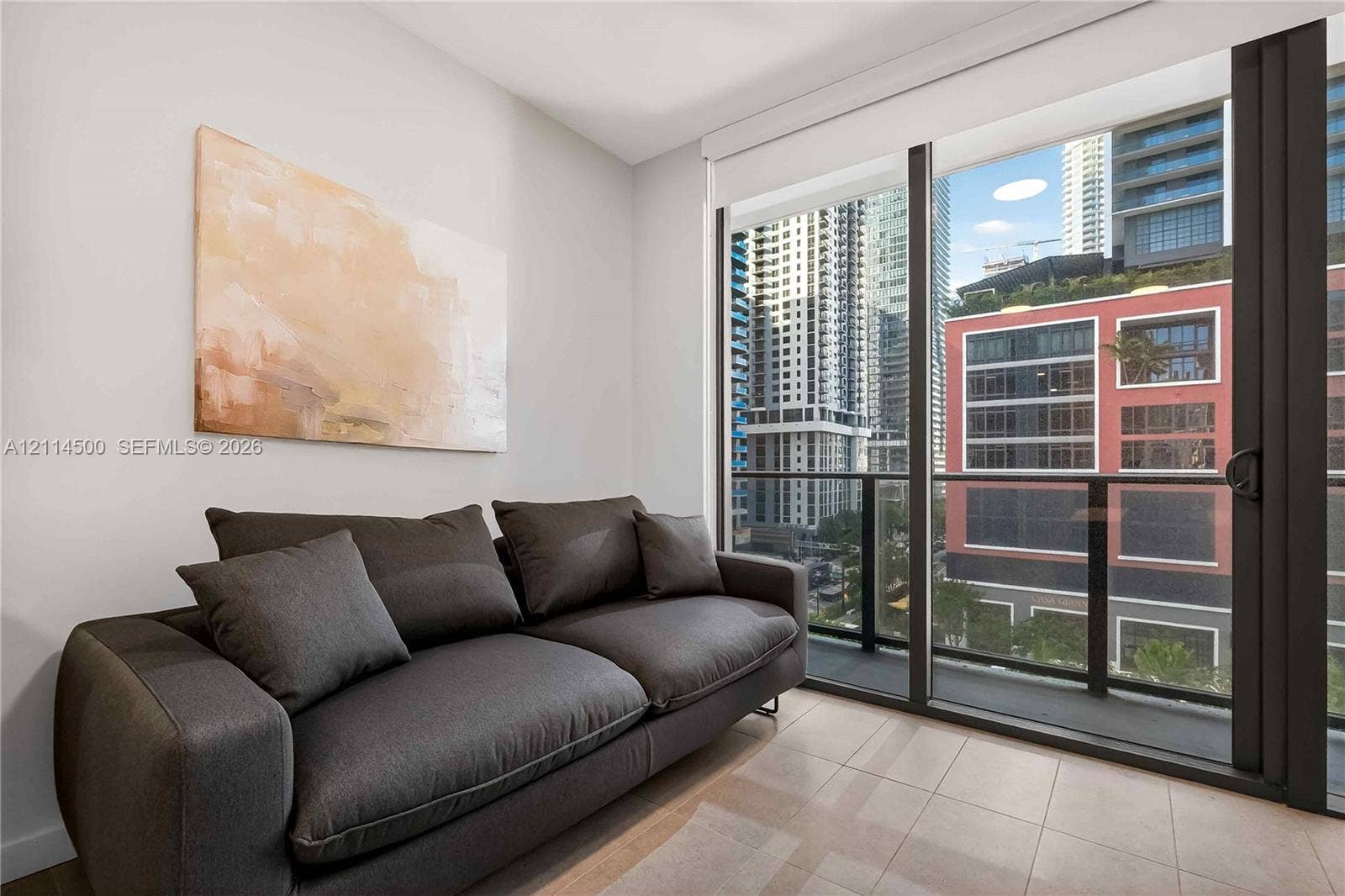 121 NE 5th Street, #712B, Miami, FL 33132 Floor-to-ceiling glass sliding door, neutral tile flooring, and integrated black metal balcony railing