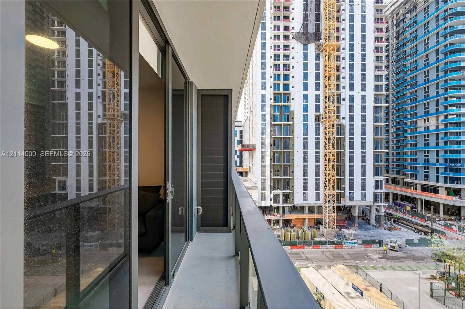 121 NE 5th Street, #712B, Miami, FL 33132 Private balcony featuring floor-to-ceiling glass sliding doors, dark metal railings, and concrete flooring