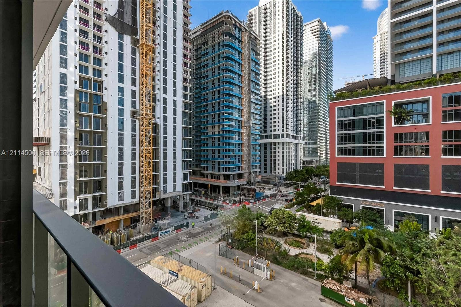 121 NE 5th Street, #712B, Miami, FL 33132 Balcony featuring a matte black metal railing overlooking an urban streetscape with high-rise structures and landscaped grounds