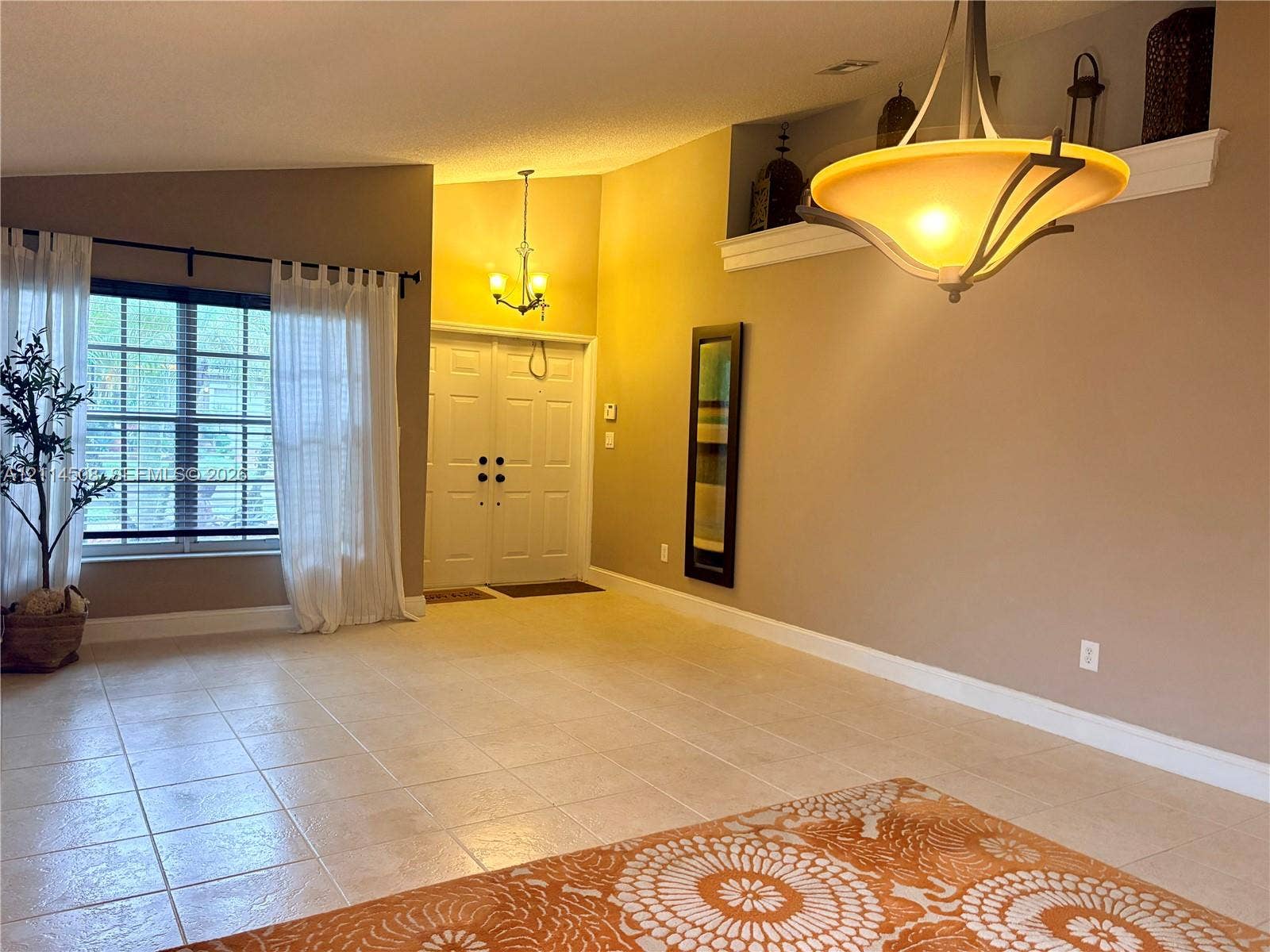 Vaulted ceilings, tiled flooring, double-entry front doors, built-in display niche, and multi-light pendant fixtures