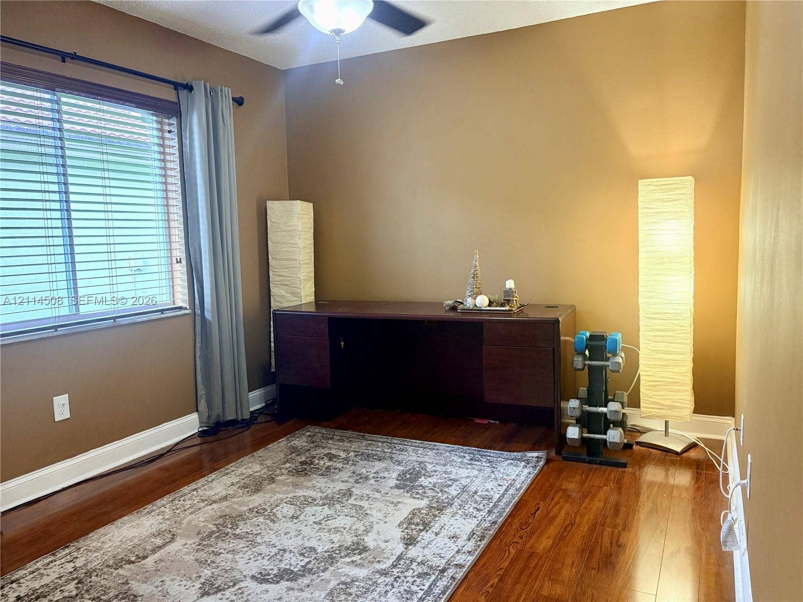 Wood-finish flooring, ceiling fan with integrated lighting, and horizontal window blinds