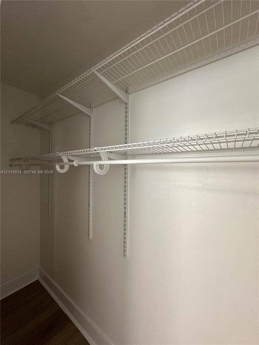 White wire shelving system featuring dual-tier hanging rods and adjustable track-mounted supports