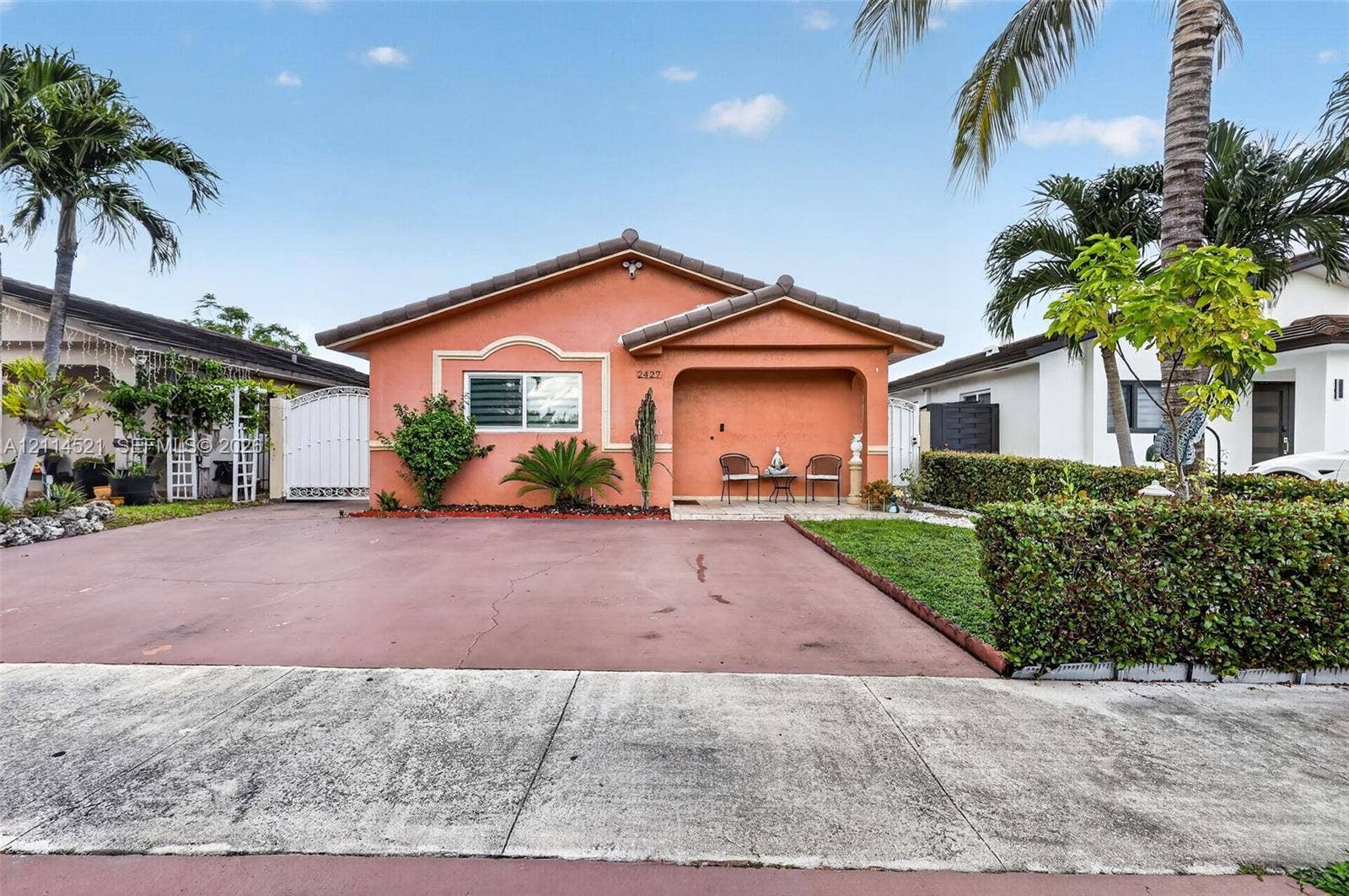 Single-story residence featuring a tile roof, stucco exterior, covered entryway, and a paved driveway