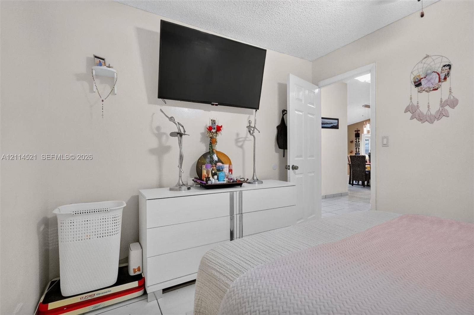 Interior space featuring neutral wall tones, six-panel interior door, and light-colored tile flooring