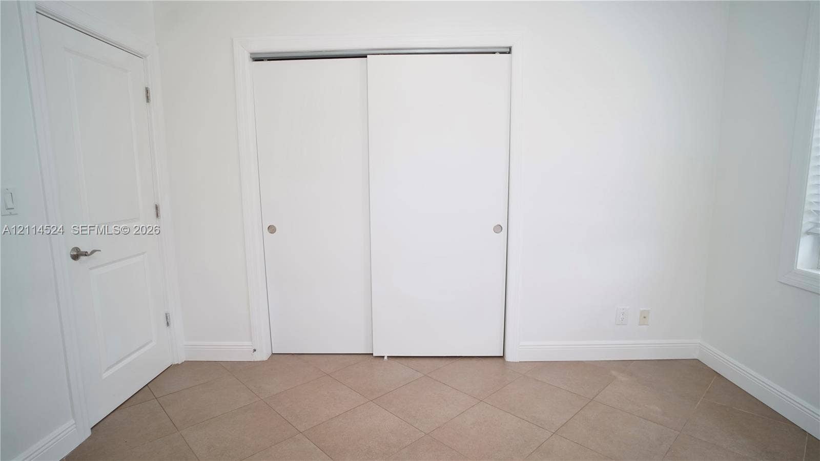 Interior space featuring ceramic tile flooring, a two-panel sliding closet, and a classic-style swinging door