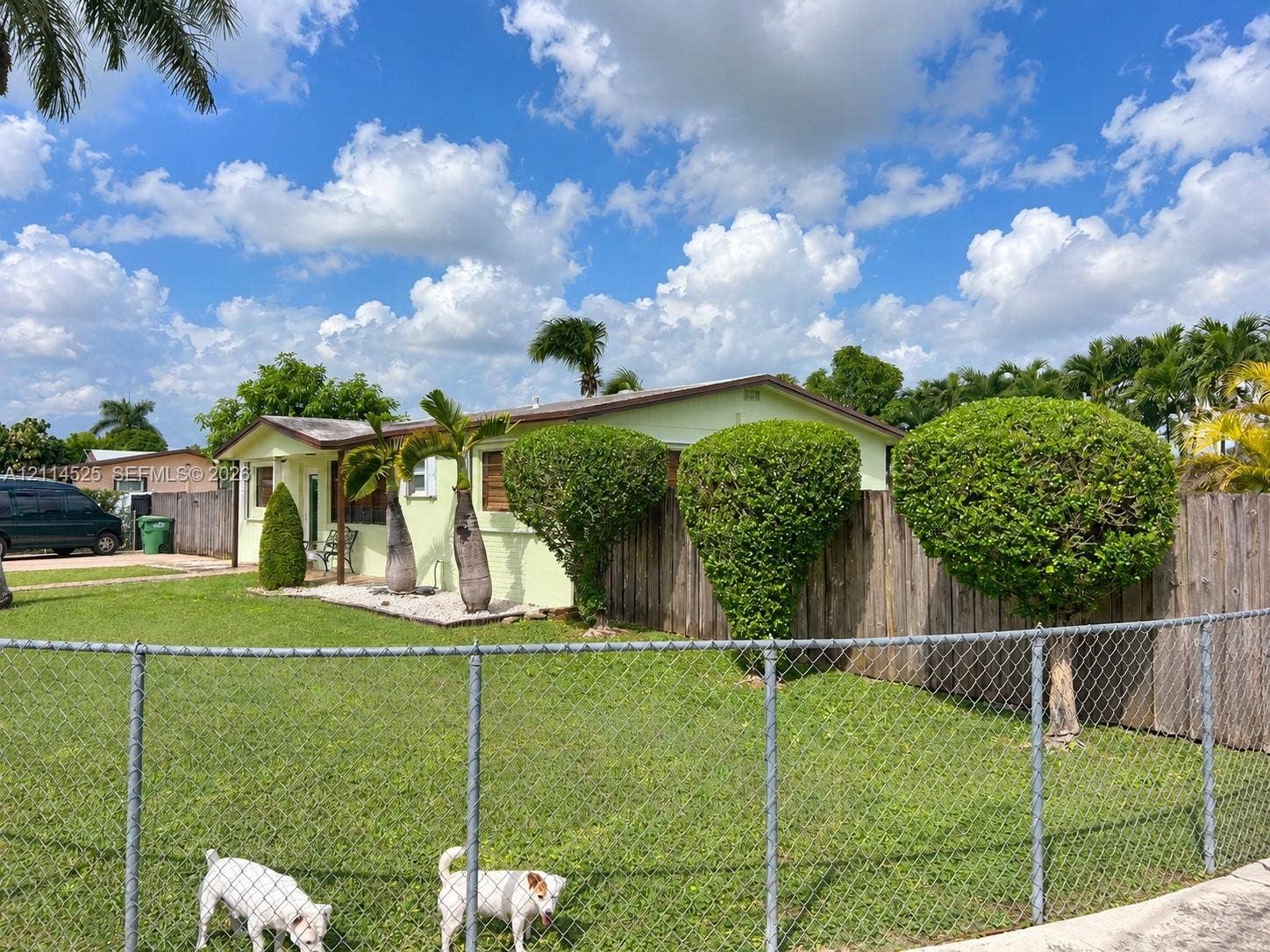 18905 SW 313th Terrace, Homestead, FL 33030 Single-story residence featuring a low-pitch roofline, exterior siding, metal chain-link perimeter fencing, and mature landscaping