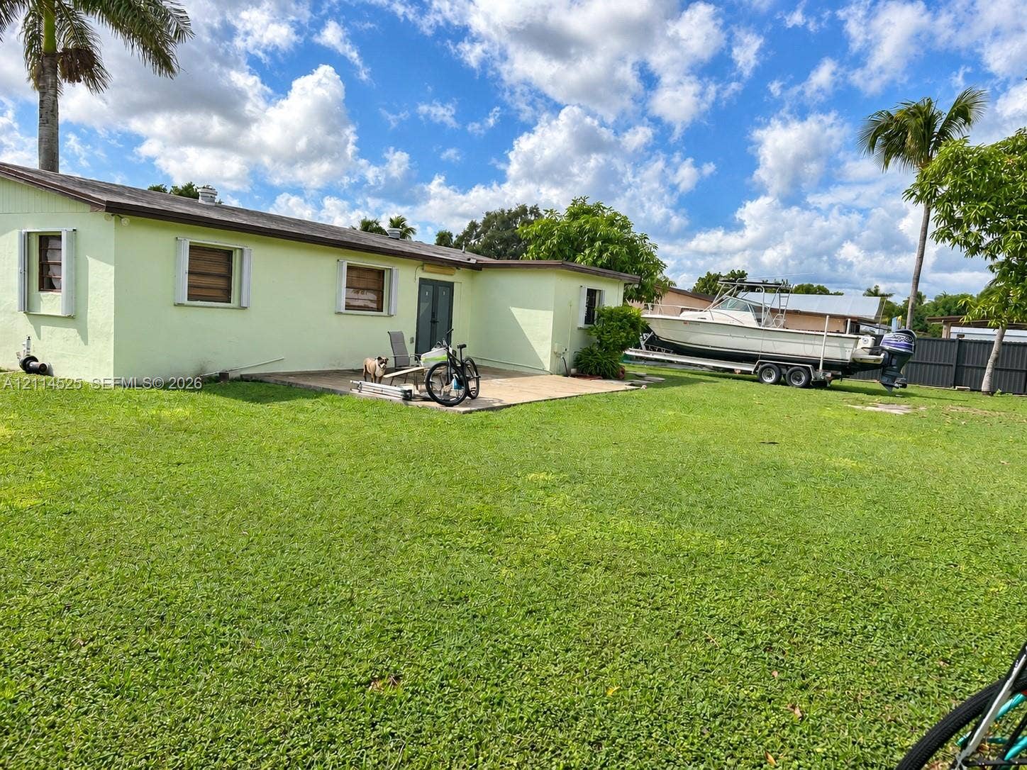 18905 SW 313th Terrace, Homestead, FL 33030 Expansive backyard featuring a large grass lawn, a paved patio, and perimeter fencing