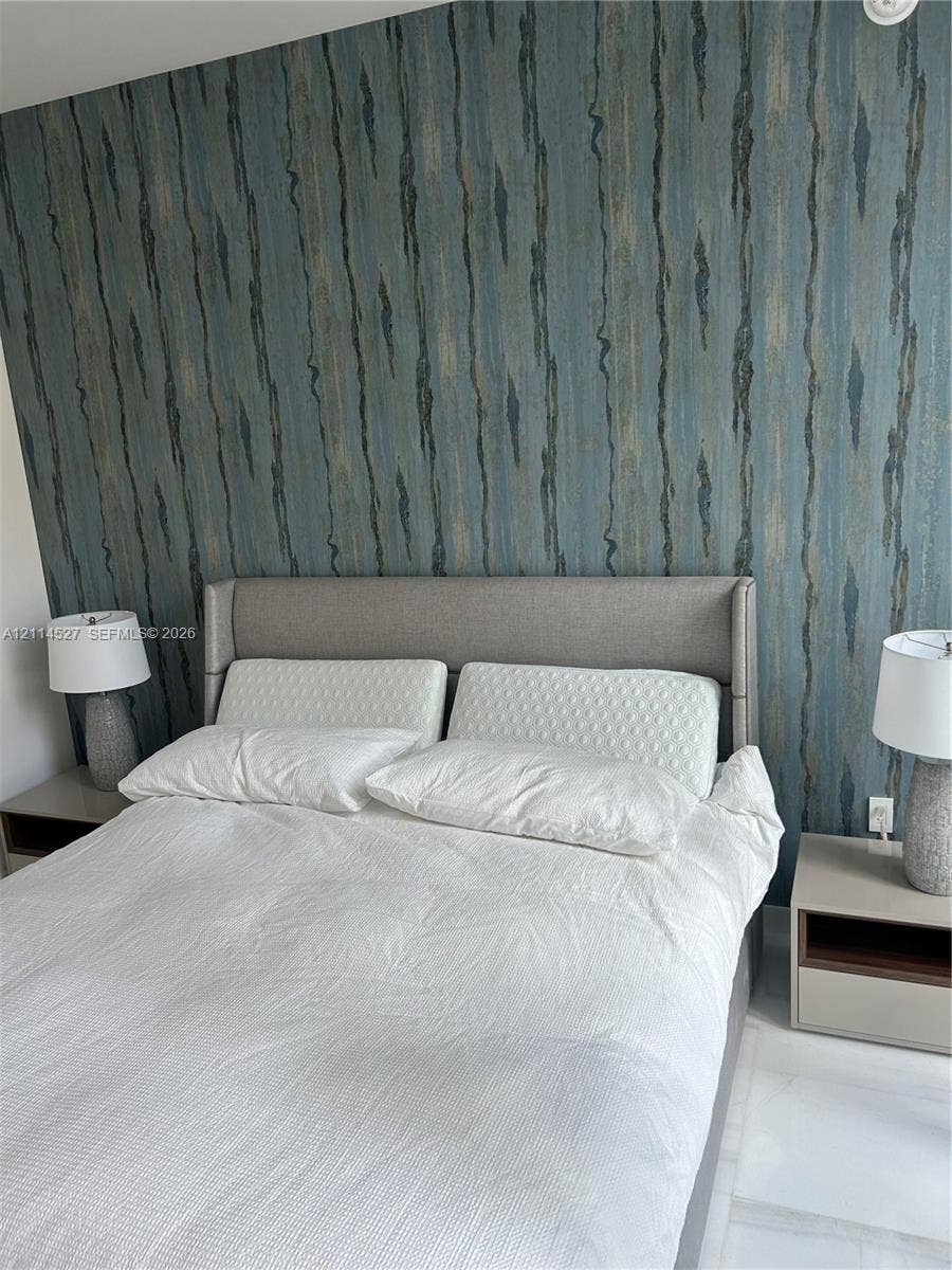 Textured blue wall covering and light-colored flooring