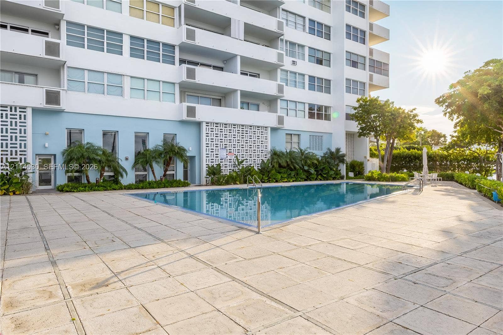 3 Island Avenue, #14L, Miami Beach, FL 33139 Swimming pool with a tile deck, decorative geometric masonry screens, and mature landscaping