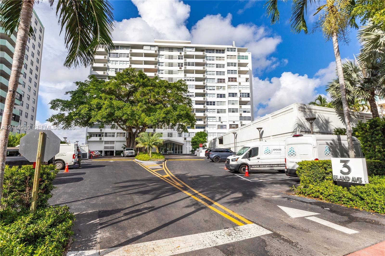 3 Island Avenue, #14L, Miami Beach, FL 33139 Multi-story mid-century architecture featuring private balconies, expansive asphalt drive, mature canopy trees, and landscaped grounds