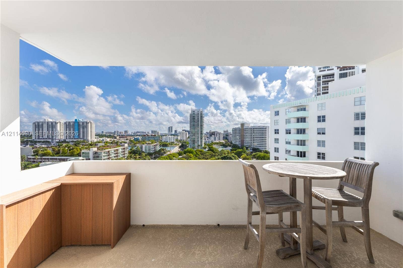 3 Island Avenue, #14L, Miami Beach, FL 33139 Covered balcony featuring concrete flooring, a custom wood-finish built-in storage unit, and expansive urban scenery