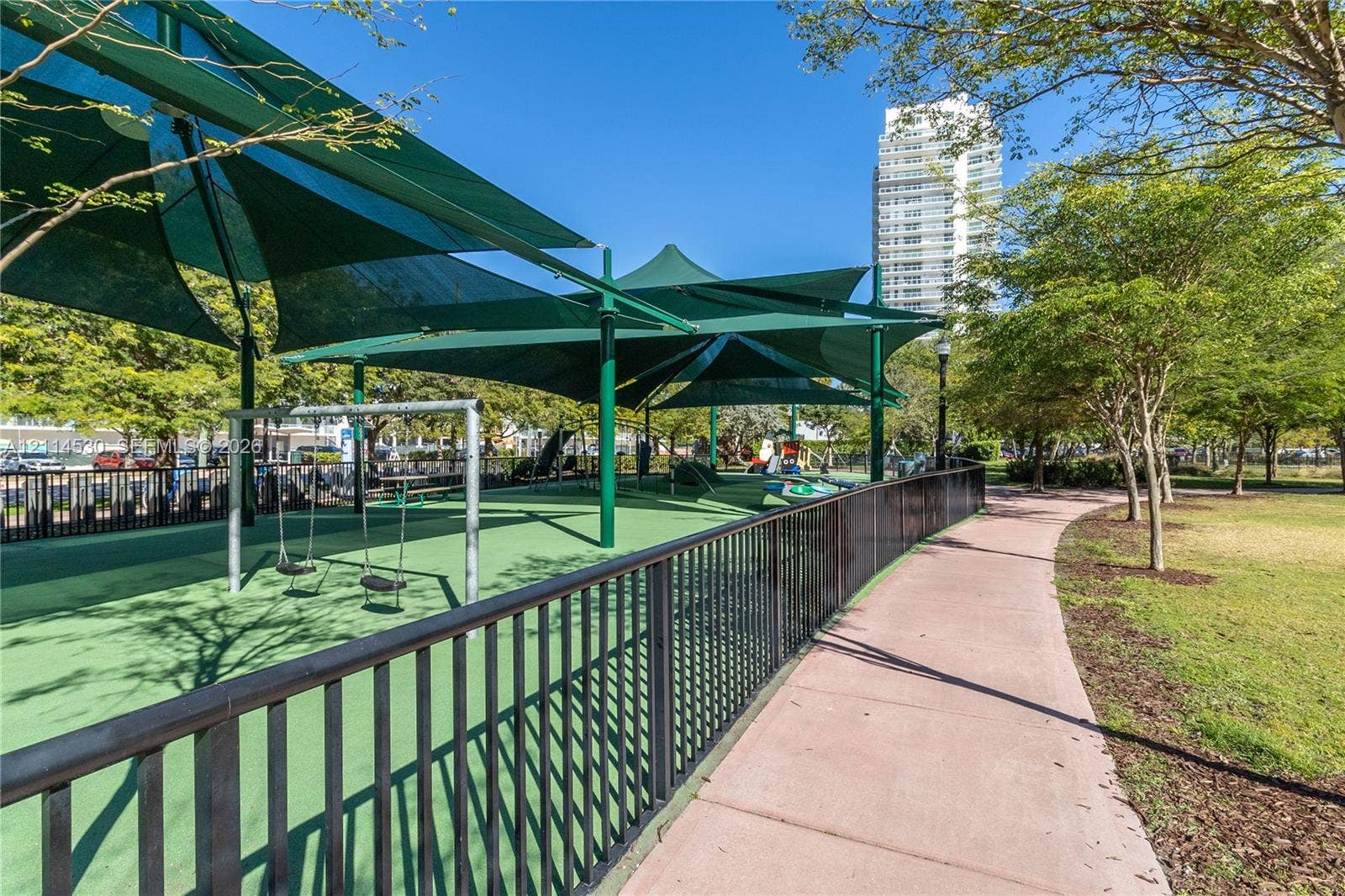 3 Island Avenue, #14L, Miami Beach, FL 33139 Recreational space featuring a synthetic turf surface, metal perimeter fencing, elevated sunshades, and a paved walkway
