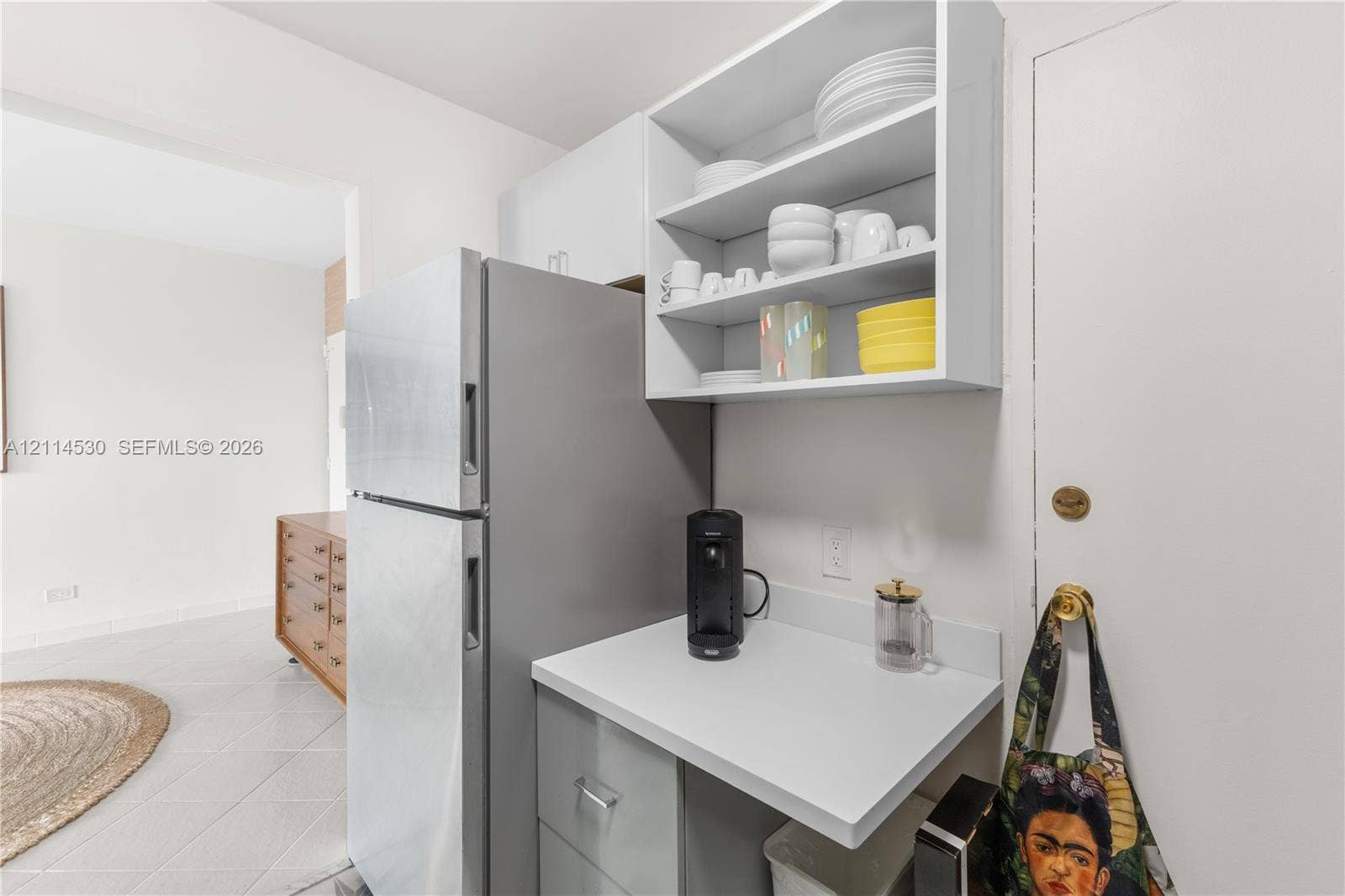 3 Island Avenue, #14L, Miami Beach, FL 33139 Kitchenette featuring matte-finish cabinetry, white solid-surface countertop, stainless steel refrigerator, and open shelving