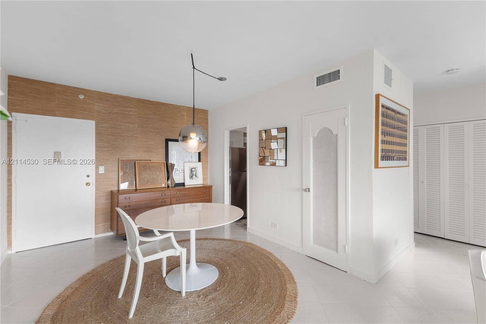 3 Island Avenue, #14L, Miami Beach, FL 33139 Textured wood-finish accent wall, spherical glass pendant lighting, interior door with a frosted glass insert, and louvered closet doors