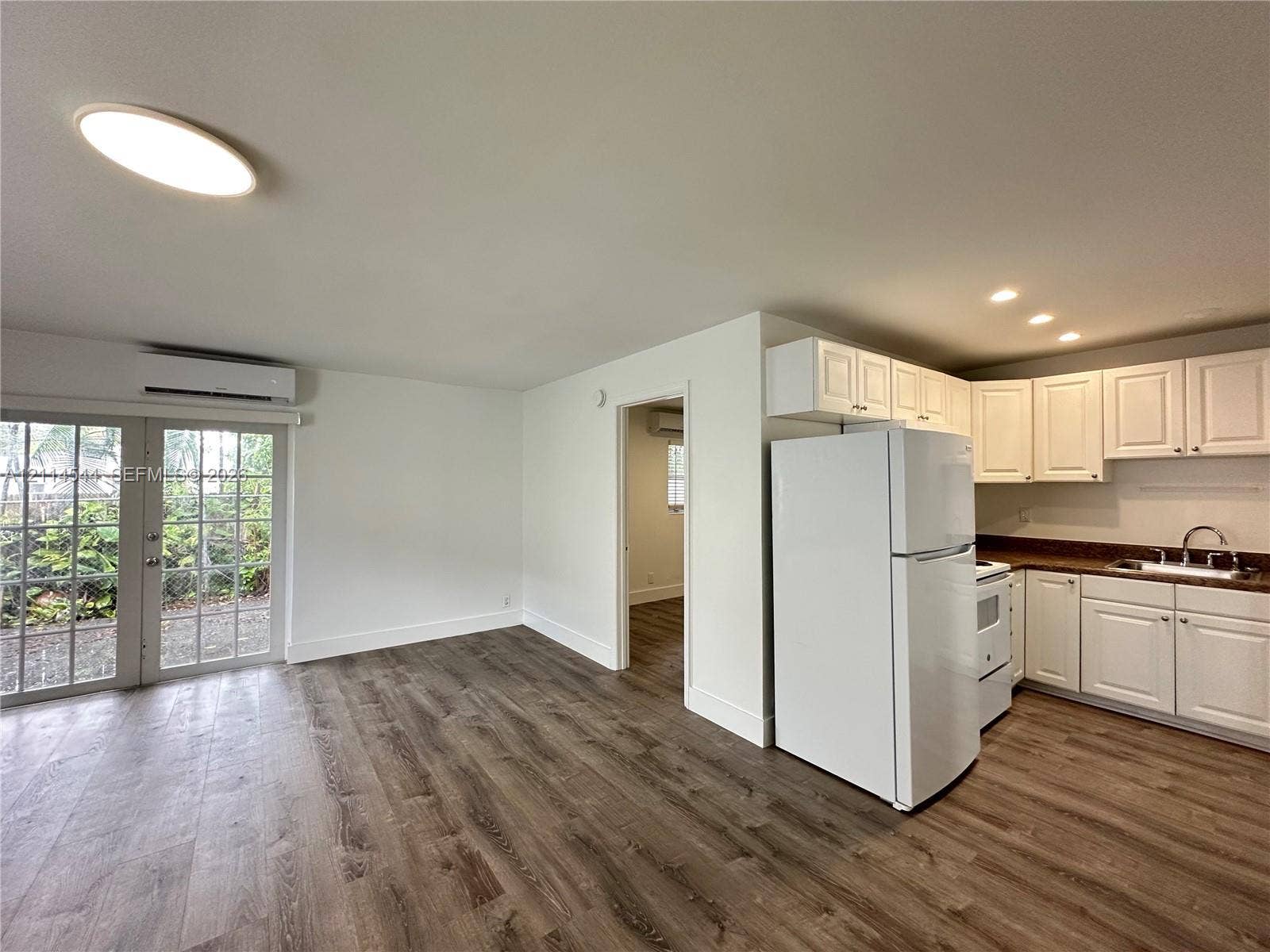 1413 N Dixie Highway, #3, Fort Lauderdale, Fort Lauderdale, FL 33304 Kitchen featuring white shaker-style cabinetry, wood-finish flooring, recessed lighting, and a glass-paneled exterior door