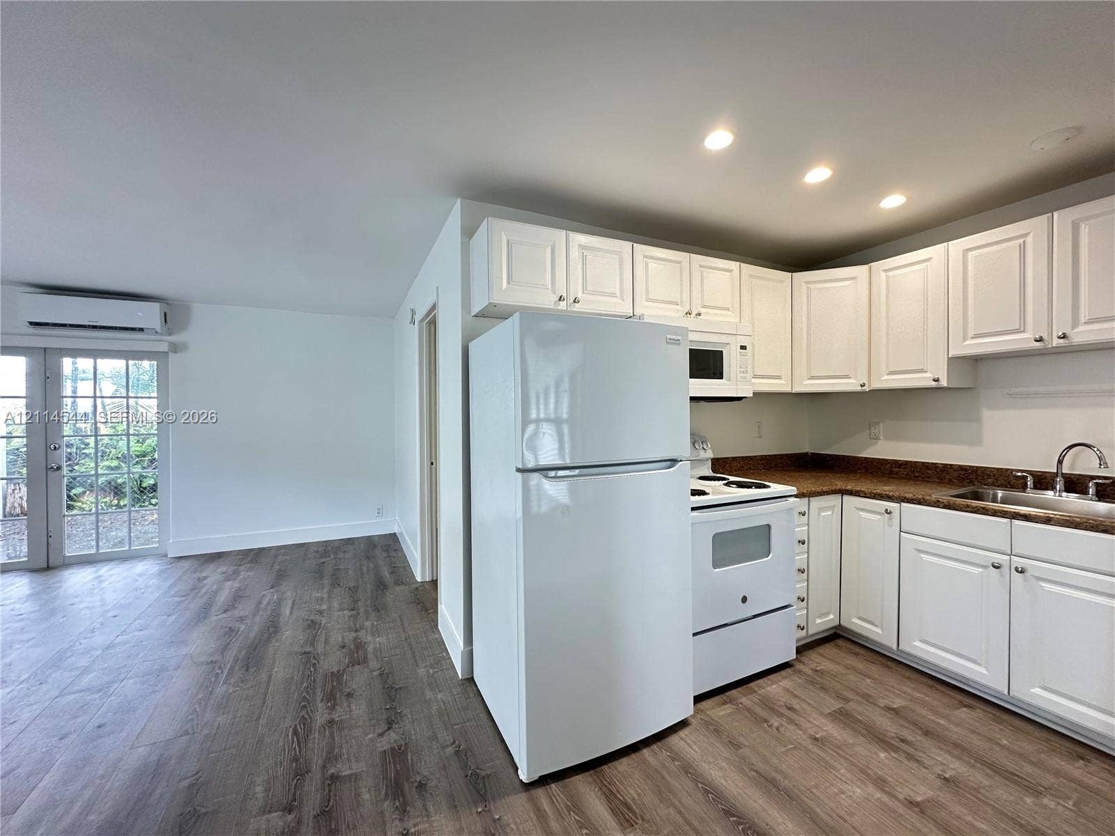 1413 N Dixie Highway, #3, Fort Lauderdale, Fort Lauderdale, FL 33304 Kitchen featuring white shaker-style cabinetry, speckled countertops, stainless steel sink, wood-finish flooring, and glass-paneled patio door