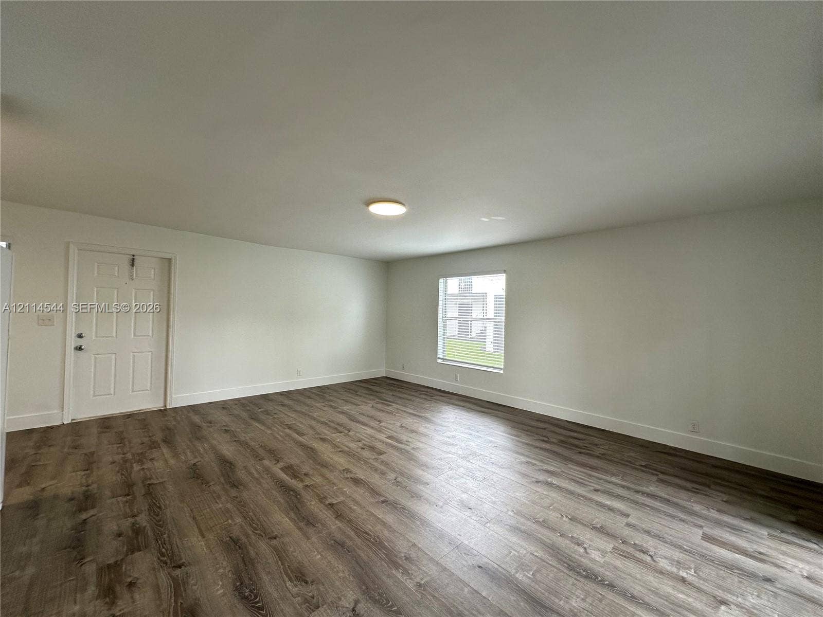 1413 N Dixie Highway, #3, Fort Lauderdale, Fort Lauderdale, FL 33304 Interior space featuring wood-finish flooring, white walls, a flush-mount ceiling light, and a single-panel window