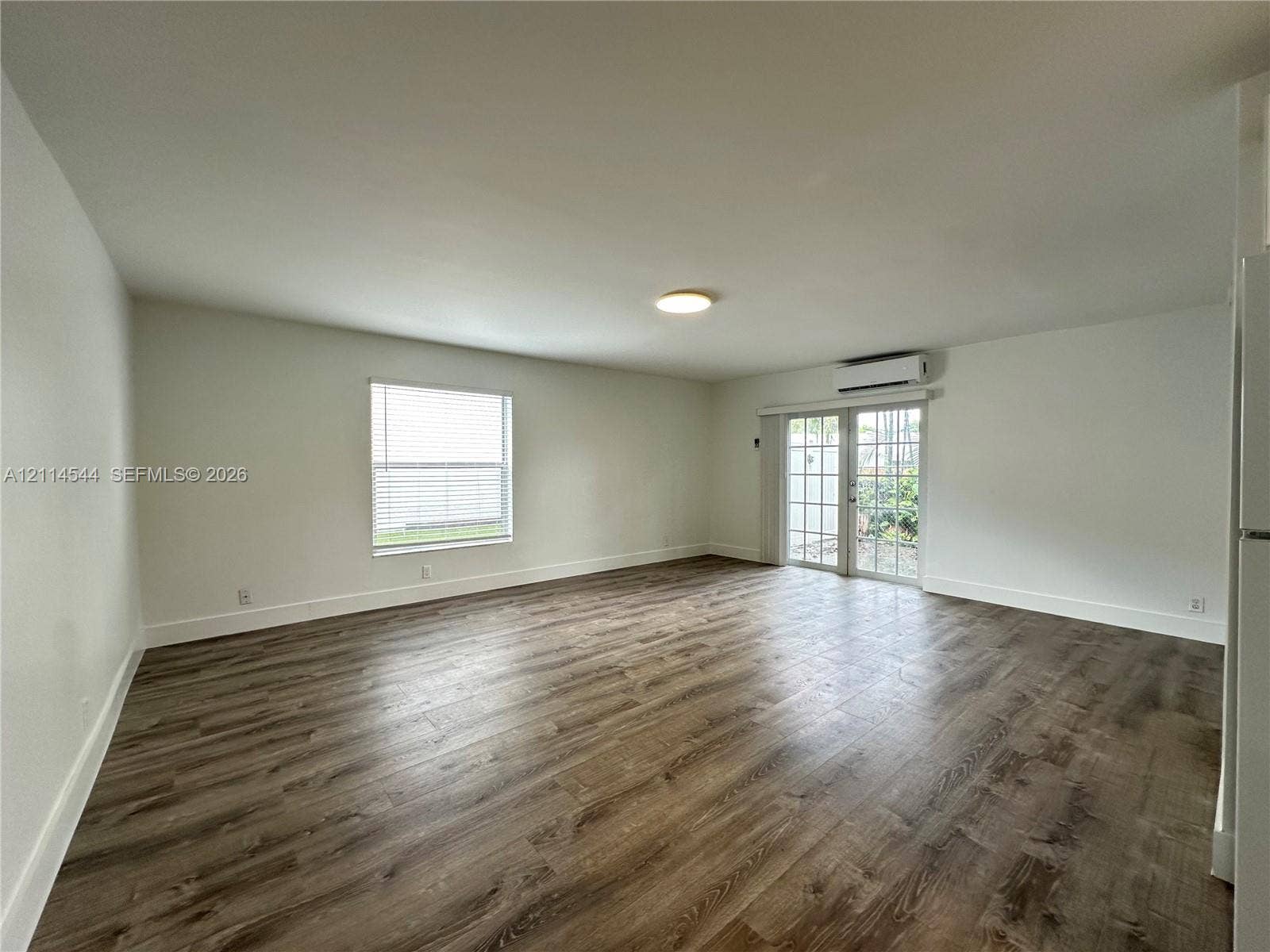 1413 N Dixie Highway, #3, Fort Lauderdale, Fort Lauderdale, FL 33304 Open-concept interior featuring wood-finish flooring, a single-hung window with blinds, and glass-paned French doors