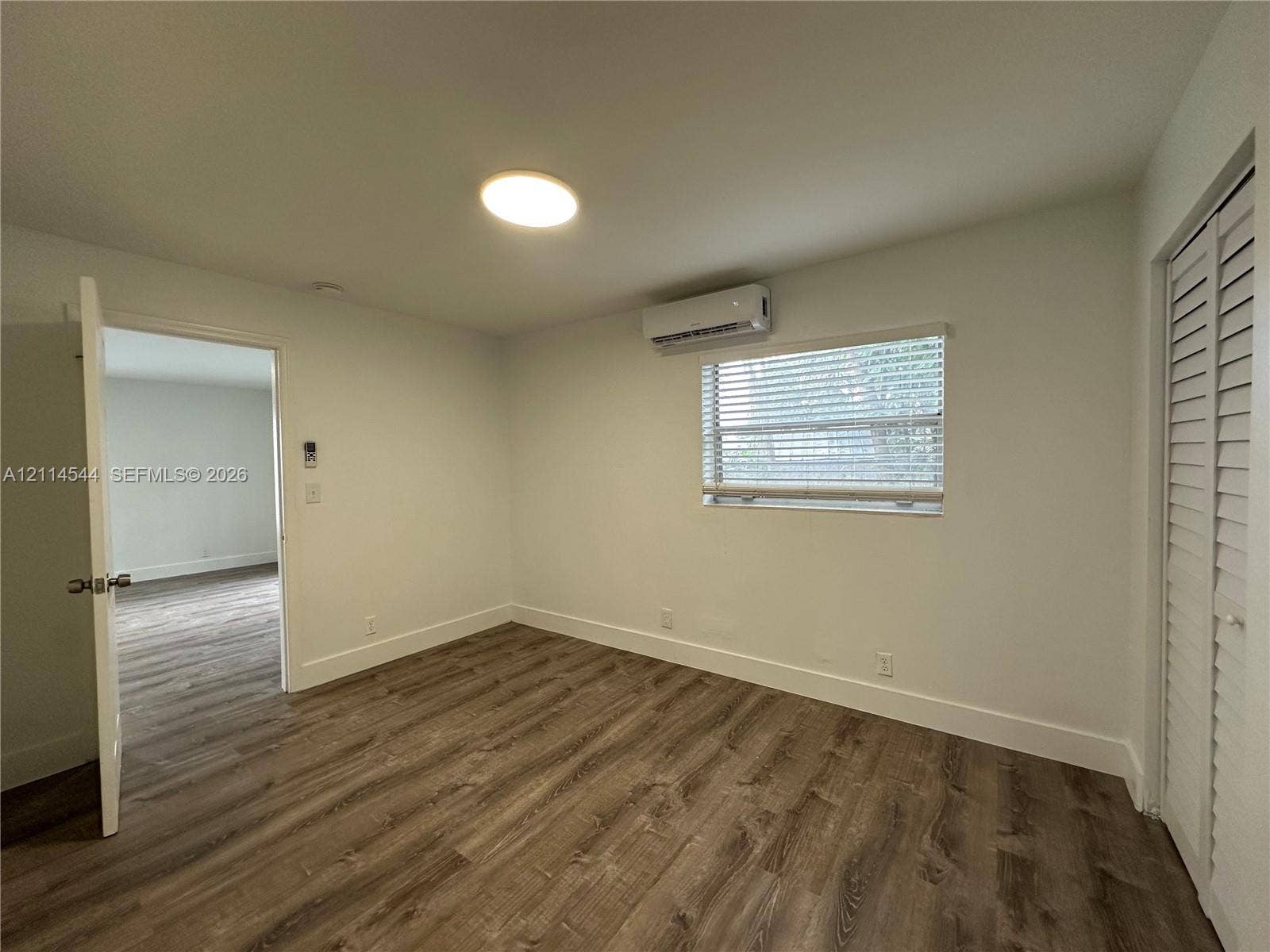 1413 N Dixie Highway, #3, Fort Lauderdale, Fort Lauderdale, FL 33304 Room featuring wood-finish flooring, a wall-mounted ductless air conditioning unit, recessed ceiling lighting, and a closet with louvered bi-fold doors